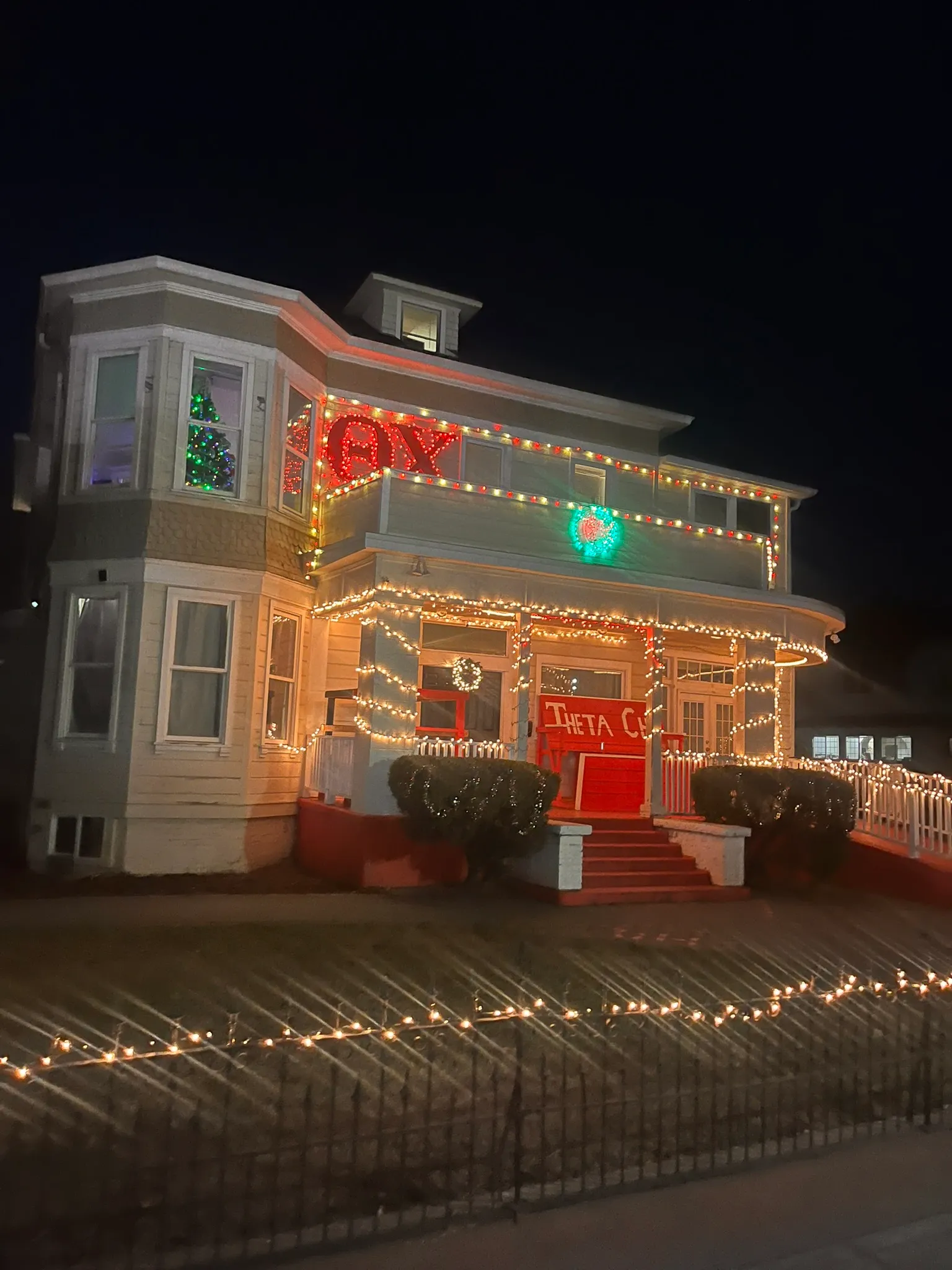 A home decorated with holiday lights at night