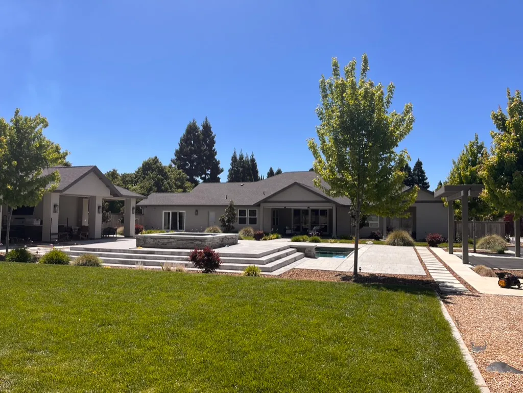 A broad residential lawn and landscaped patio