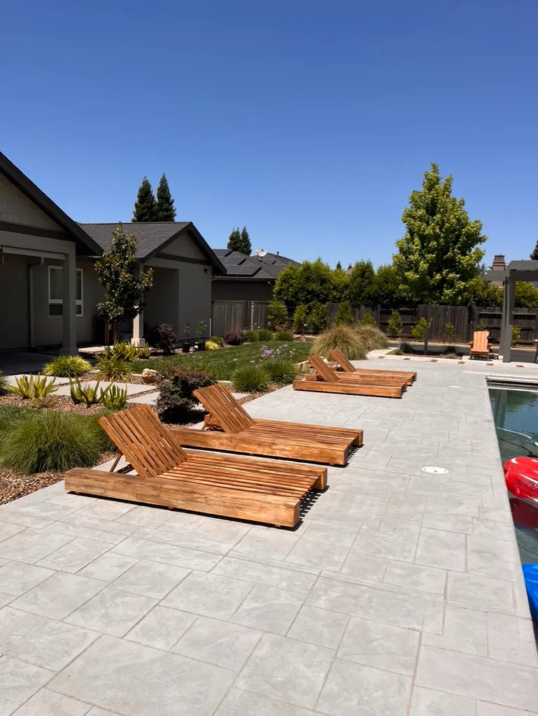 A poolside patio with outdoor lounge chairs