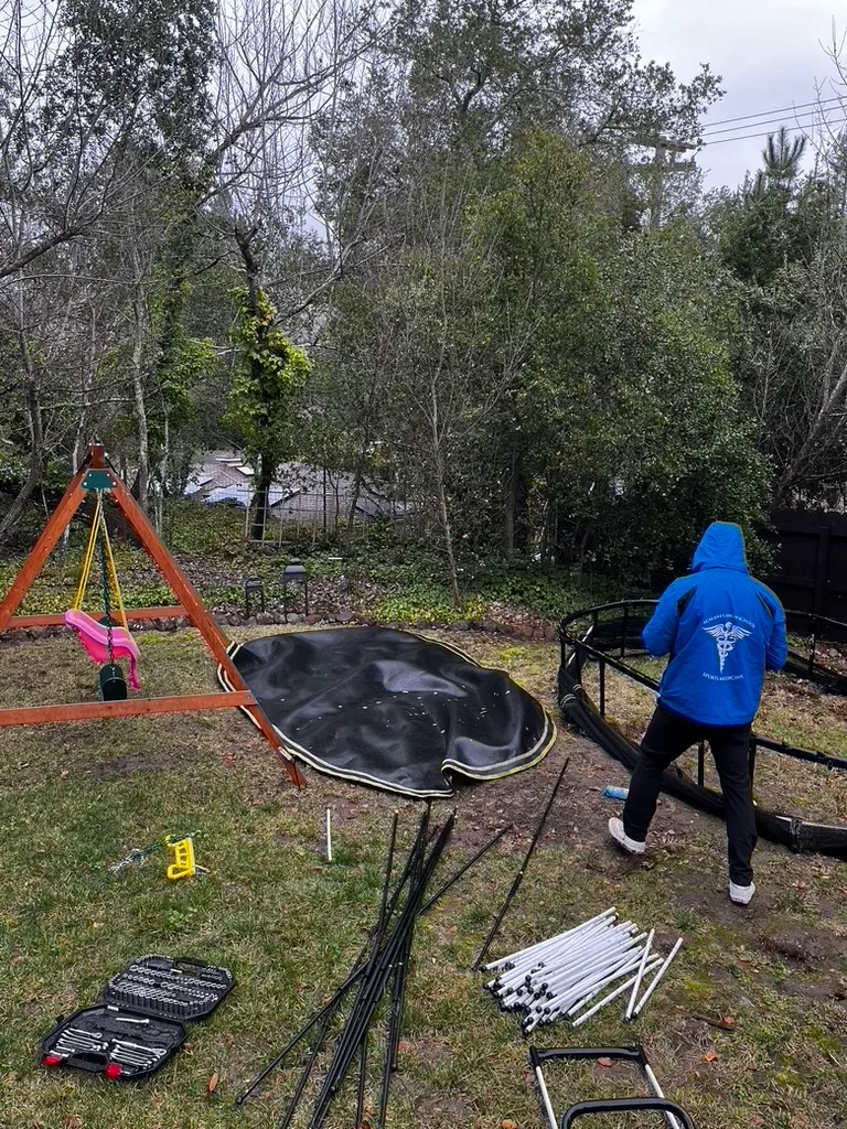 Trampoline assembly in progress in a residential backyard