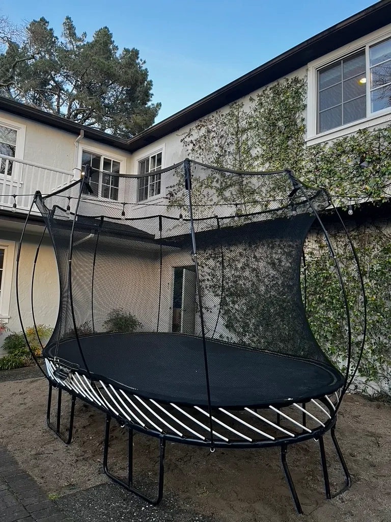 A completed trampoline set up on a backyard patio