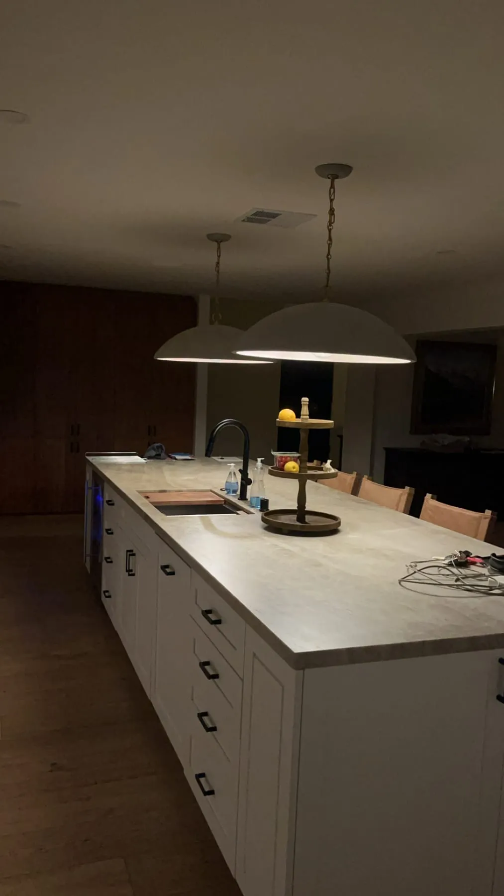A large kitchen island beneath pendant lights
